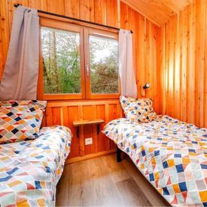 - 2 lits dans une chambre dotée de murs en bois et de fenêtres dans l'établissement Camping 3 étoiles - Piscine - ccafbbc, à Huelgoat