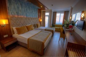 ein Hotelzimmer mit einem Bett und einer Couch in der Unterkunft grand Şeker hotel in Side