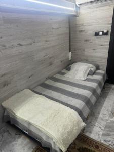 ein Bett in einem Zimmer mit einer Holzwand in der Unterkunft Central location in Chişinău