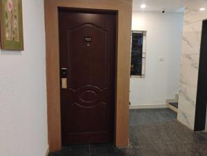 a brown door with a number on it in a hallway at Hotel O Mirage Suites in Bengaluru +6 photos