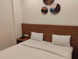 a bedroom with a bed with two mirrors on the wall at Hotel O Mirage Suites in Bengaluru