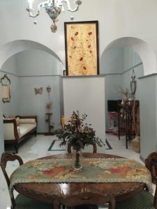 d'un salon avec une table et une peinture murale. dans l'établissement CASA SEÑORIAL CON PISCINA. CASA DONNA ISABEL, à Peñaflor