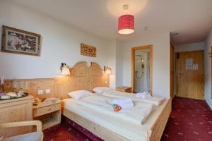 a bedroom with a large bed and a desk at Hotel Relais Alpin in Les Mosses