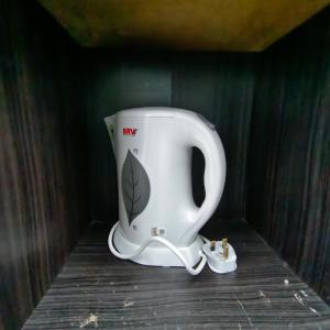 东贡岸Cybercity Jannath homestay near to Airport KKIA的架子上放着一个白色的咖啡壶