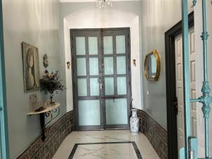 une porte dans une pièce avec un sol carrelé et un couloir dans l'établissement CASA SEÑORIAL CON PISCINA. CASA DONNA ISABEL, à Peñaflor