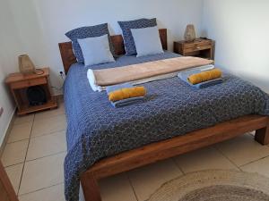 a bedroom with a bed with a blue comforter and pillows at L'Escapade des Hauts location saisonnière avec jacuzzi in Le Tampon