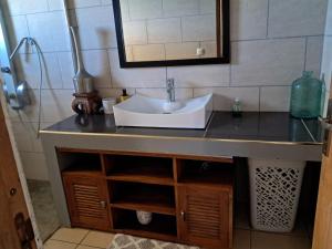 a bathroom vanity with a sink and a mirror at L'Escapade des Hauts location saisonnière avec jacuzzi in Le Tampon +34 photos