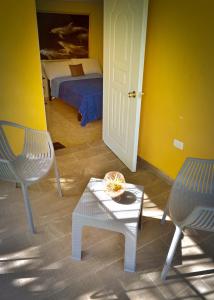 a room with a bed and a table and chairs at Refugio Encantador in Santo Domingo