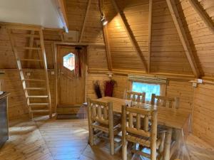 a wooden dining room with a wooden table and chairs at Camping 3 étoiles - Piscine - eeeddg in Saint-André-des-Eaux