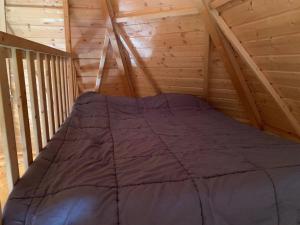 a bed in the attic of a log cabin at Camping 3 étoiles - Piscine - eeeddg in Saint-André-des-Eaux +86 photos
