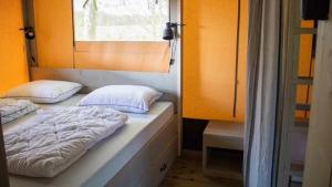 two beds in a room with a window at ZEcamping 3 étoiles pet friendly avec sauna bar et restaurant in Priziac