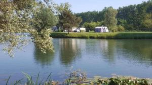 a view of a lake with a tent in the background at Camping 3 étoiles - efb0hg in Arques-la-Bataille
