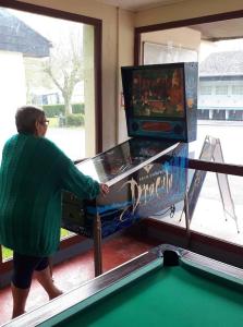 a woman standing in front of a pinball machine at Camping 3 étoiles - efb0hg in Arques-la-Bataille