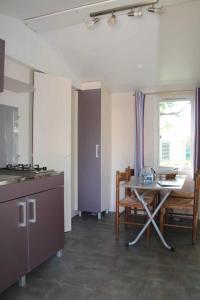 a kitchen with a table and a table and chairs at ZEcamping 3 étoiles toboggans piscine locatif 25m2 5 pers in Peynier
