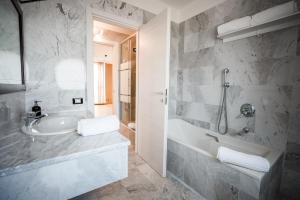 un bagno con lavandino, vasca e doccia di Duo LUXURY SUITES a Verona