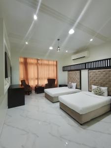 ein Hotelzimmer mit zwei Betten und einer Couch in der Unterkunft Qasayed Hotel Salalah, فندق قصائد صلالة in Salalah + 36 Fotos