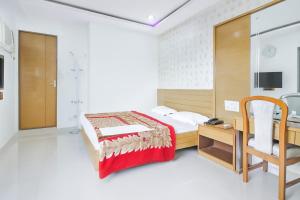 a bedroom with a bed and a desk and a chair at Hotel Sarita - Near Surat Railway Station in Surat +19 photos