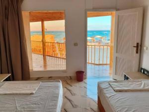 deux lits dans une chambre avec vue sur l'océan dans l'établissement Sea View Camp Nuweiba, à Wāsiţ
