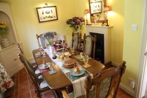 a dining room table with cakes and desserts on it at 3-bedroom cottage set in a large enclosed garden in Thatcham