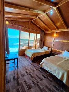 une chambre avec deux lits et une vue sur l'océan dans l'établissement Sea View Camp Nuweiba, à Wāsiţ
