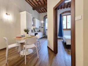 a dining room and kitchen with a table and chairs at "Suite del Borgo" charming flat at 30 min from Florence, 2 Smart TV in San Giovanni Valdarno