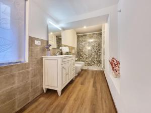 a bathroom with a toilet and a sink and a tub at "Suite del Borgo" charming flat at 30 min from Florence, 2 Smart TV in San Giovanni Valdarno +24 photos