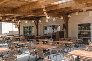 ein leeres Restaurant mit Holztischen und -stühlen in der Unterkunft Camping 5 étoiles - Parc aquatique - eebfed in Sainte-Catherine-de-Fierbois
