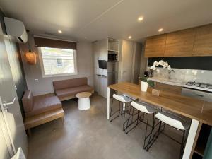 a kitchen with a counter and a table in a room at Camping 4 étoiles - Piscine - ccbbecd in Le Grau-dʼAgde