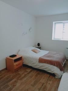 ein Schlafzimmer mit einem Bett und einem Holzboden in der Unterkunft Studio de la ferme des huis 