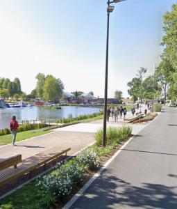 ein Park mit Menschen, die auf einem Gehweg spazieren gehen, und einem Fluss in der Unterkunft Room New Zealand in Le Quesnoy