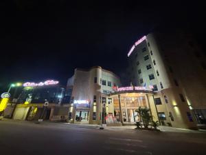 Un edificio con un cartel en la noche. en FOPROLUX Palace, en Douala