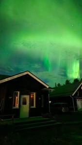 a house with the aurora in the sky at Riverfront Aurora Chalet in Kiruna