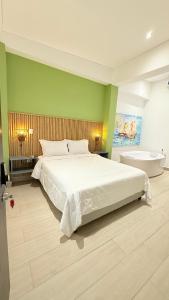 a bedroom with a large white bed and a tub at Hotel Gallery Boutique in Pereira