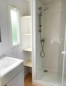 a white bathroom with a shower and a sink at Camping 3 étoiles - eed0ca in Priziac +104 photos