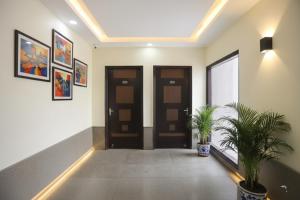 a hallway with two doors and two potted plants at Via Next Home - Nr IMT Chowk Manesar in Gurgaon