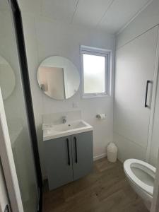 a white bathroom with a sink and a toilet at ZEcamping 4 étoiles animaux acceptés bain à remous sauna et solarium in Apremont