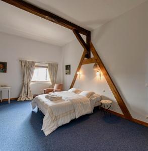 een slaapkamer met een groot bed op zolder bij Domaine des Rochaules 