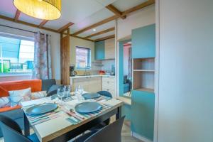 eine Küche und ein Wohnzimmer mit Tisch und Stühlen in der Unterkunft Camping 4 étoiles - Piscine - cbgcb0b in Saint-Jean-de-Monts