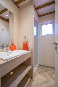 ein Badezimmer mit weißem Waschbecken und Fenster in der Unterkunft Camping 4 étoiles - Piscine - cbgcb0b in Saint-Jean-de-Monts + 44 Fotos