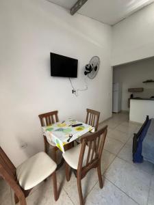 a dining room with a table and chairs and a tv at Renascer Suites in Búzios