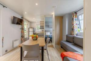 a kitchen and dining room with a table and a couch at Camping 3 étoiles - Piscine - ccafbhe in Talmont-Saint-Hilaire