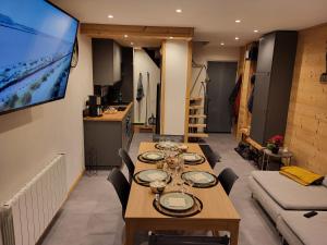 Un comedor con una mesa larga con copas de vino. en Les biches du Soula 5 couchages proche piste ski, en Les Angles