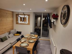 una sala de estar con una mesa y un sofá en Les biches du Soula 5 couchages proche piste ski, en Les Angles