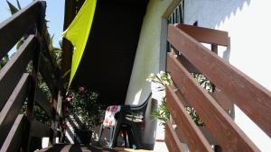 a chair sitting outside of a building with a yellow umbrella at Agave Apartman in Velence