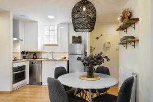 a kitchen with a white table and chairs in a kitchen at Apartamento Vico in Escarrilla