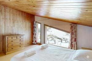 une chambre avec un grand lit et une fenêtre dans l'établissement Les Arolles - La Plagne 1800, à La Plagne Tarentaise