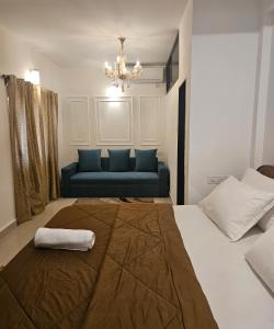 卡兰古特Villa platinum 4 BHK Calangute的一间卧室，有一张床和一张蓝色沙发 更多31张照片
