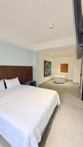 a bedroom with a large bed and a bath tub at Hotel Gallery Boutique in Pereira