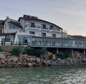 a large building on a rocky shore with the water at Stanca Dunarii in Nufăru