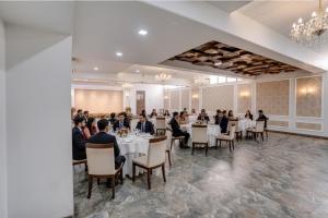 奥兰加巴德Via Heritage Palace - CIDCO Bus Stand的一群坐在宴会厅桌子上的人